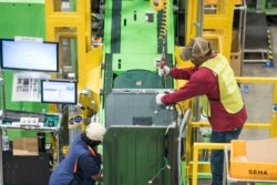 FILE - Workers build washing machines on the assembly line at a Samsung facility in Newberry, South Carolina, March 16, 2018.
