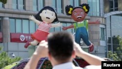 A man takes photos of a flowerbed decoration for the upcoming Forum on China-Africa Cooperation (FOCAC) in Beijing, Aug. 31, 2018.