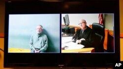William Strampel, left, appears during his video arraignment, with Judge Richard D. Ball, right, Tuesday, March 27, 2018, in East Lansing, Mich. Strampel, a Michigan State University official who oversaw Larry Nassar, was arrested Monday amid an investiga