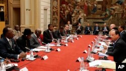 French President Francois Hollande, right, talks during the round table photo at the "Paris' Security in Nigeria summit", at the Elysee Palace, in Paris, May 17, 2014.