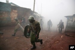 Riot police are caught in tear gas during running battle with opposition supporters in Kibera Slums in Nairobi, Kenya,Oct. 26, 2017.