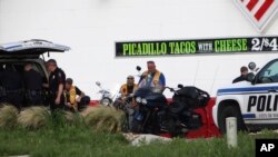 FILE - Police detain and watch members of various motorcycle clubs near a restaurant in Waco, Texas, May 17, 2015.