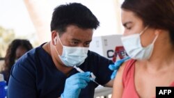 និស្សិត​ម្នាក់​ទទួល​ការ​ចាក់​វ៉ាក់សាំង​បង្ការ​ជំងឺ​កូវីដ១៩​​ Pfizer ដូស​ទី​១ ​នៅ​គ្លីនិក​​ចល័ត​មួយ​នៅ​ទី​ក្រុង Long Beach រដ្ឋ California កាល​ពី​ថ្ងៃ​ទី​១១ ខែ​សីហា ឆ្នាំ​២០២១។