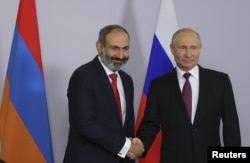 Russian President Vladimir Putin shakes hands with Armenian Prime Minister Nikol Pashinyan during their meeting in Sochi, Russia, May 14, 2018.