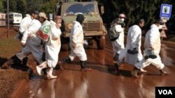 Para pekerja bersiap melakukan pembersihan limbah beracun yang menggenangi jalan-jalan di Devecser, Hungaria barat.