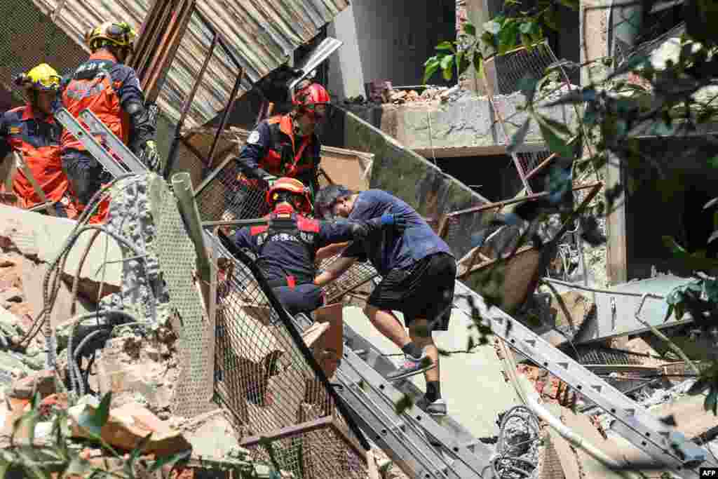 This photo taken by Taiwan&#39;s Central News Agency (CNA) on April 3, 2024 shows emergency workers assisting a survivor after he was rescued from a damaged building in New Taipei City, after a powerful&nbsp;earthquake hit Taiwan&#39;s east.
