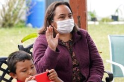 Ofelia Aguilar watches the swearing in of Joe Biden as U.S. president, Jan. 20, 2021, in Homestead, Fla. Immigrants cheered Biden's plan to provide 11 million people without legal U.S. status a path to citizenship.