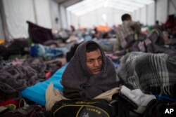 Alcides Padilla, from Honduras, wakes up at the Jesus Martinez stadium in Mexico City, Nov. 7, 2018.