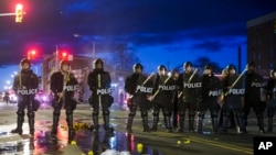 Polisi berjaga-jaga setelah perusuh beraksi di Baltimore (27/4).