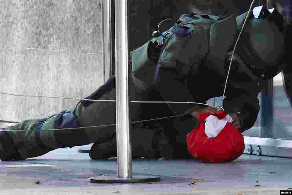 Seorang ahli detonasi bom memeriksa sebuah paket yang dicurigai sebagai bom, di pintu Bank Sentral Venezuela di Caracas, Venezuela.
