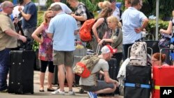 British tourists queue with their luggage to leave by charter flight from the international airport in Mombasa, Kenya Friday, May 16, 2014.