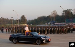 FILE - Myanmar's President Thein Sein, standing in an open vehicle, inspect officers and soldiers during a ceremony to mark the 67th anniversary of Independence Day in Naypyitaw, Jan. 4, 2015.