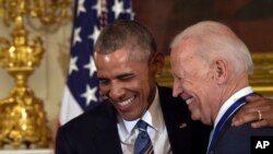 FILE - President Barack Obama laughs with Vice President Joe Biden during a ceremony in the State Dining Room of the White House in Washington, Jan. 12, 2017.