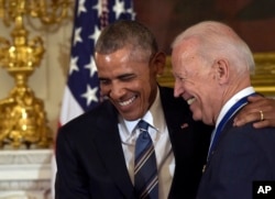President Barack Obama laughs with Vice President Joe Biden during a ceremony in the State Dining Room of the White House in Washington, Jan. 12, 2017.