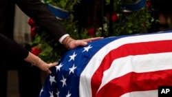 ຄອບຄົວ ຄາຣ໌ເຕີ ພາກັນສະແດງຄວາມເຄົາລົບໃນລະຫວ່າງພິທີ ຄະນະທີ່ທຸລຊາດຖືກປົກຢູ່ຫີບສົບຂອງອະດີດປະທານາທິບໍດີ ຈິມມີ ຄາຣ໌ເຕີ ທີ່ດອມໄວ້ໃນພິທີແຫ່ງຊາດ, ຫໍລັດຖະສະພາ, ວັນທີ 7 ມັງກອນ 2025, ໃນນະຄອນຫຼວງວໍຊິງຕັນ.