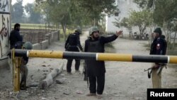 Pakistan security guards police station entrance after attack, Bannu, Dec. 10, 2012.