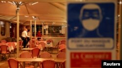 Waiters are seen inside "La Chicoree" restaurant a few minutes before the start of the late-night curfew introduced as part of coronavirus restrictions, in Lille, France, Oct. 16, 2020.