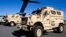 FILE - Mine-resistant, ambush-protected vehicles (MRAP), produced by Navistar, are loaded onto an airplane at Charleston Air Force Base in North Charleston, S.C.