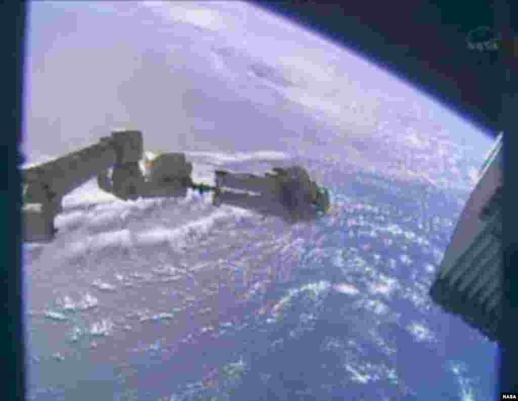 Astronaut Mike Hopkins is seen at the end of the robotic arm on the International Space Station during a spacewalk, Dec. 24, 2013.