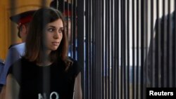 A member of the female punk band "Pussy Riot", Nadezhda Tolokonnikova, is escorted before a court hearing to appeal for parole at the Supreme Court of Mordovia in Saransk, July 26, 2013. 