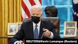 USA, Washington, U.S. President Joe Biden signs an exectutive order repealing foremer President Trump’s ban