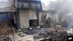 Smoke rises from damaged shops after fighting between Taliban and Afghan security forces in Kunduz city, northern Afghanistan, Sunday, Aug. 8, 2021. (AP Photo/Abdullah Sahil)