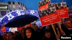FILE - Supporters of Turkey's main opposition Republican People's Party (CHP) hold placards with pictures of four former ministers while shouting anti-government slogans during a protest in Istanbul, Turkey, Dec. 17, 2014.