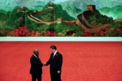 Ghana's President Nana Akufo-Addo, left, shakes hands with Chinese President Xi Jinping during the Forum on China-Africa Cooperation held at the Great Hall of the People in Beijing, Sept. 3, 2018.