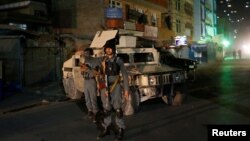 Dua polisi Afghanistan siaga mengamankan lokasi masjid Syiah di Kabul, Afghanistan pasca serangan hari Selasa (11/10) malam. 