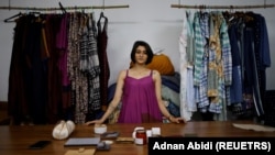 Kriti Tula is a fashion designer in New Delhi, India. Here she stands next to the clothes made from repurposed unused fabric at her factory on November 3, 2021. (REUTERS/Adnan Abidi)