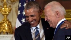 FILE - President Barack Obama laughs with Vice President Joe Biden during a ceremony in the State Dining Room of the White House in Washington, Jan. 12, 2017. 