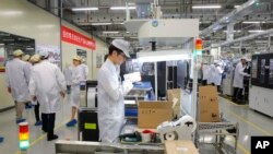 រូប​ឯកសារ៖ បុគ្គលិក​ក្រុម​ហ៊ុន​ទូរស័ព្ទ Huawei នៅ​ក្នុង​រោង​ចក្រ​ក្នុង​ទីក្រុង Dongguan ប្រទេស​ចិន កាល​ពី​ខែ​មីនា ២០១៩។