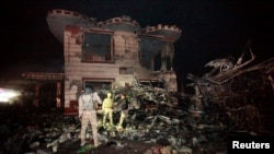 Anggota pasukan keamanan Irak memeriksa lokasi serangan bom bunuh diri di sebuah pompa bensin di Hilla, Baghdad, Irak (24/11). 