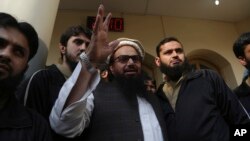 FILE - Hafiz Saeed, head of the Pakistan's Jamaat-ud-Dawa group, waves to supporters at a mosque in Lahore, Pakistan, Nov. 24, 2017.