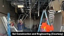 ພະນັກງານຂອງບໍລິສັດ ກໍາລັງເຮັດວຽກຢູ່ສະຖານທີ່ແຫ່ງນຶ່ງ.