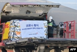 FILE - A South Korean worker unloads cargo containing Pfizer's antiviral COVID-19 pill, Paxlovid, at a cargo terminal of the Incheon International Airport in Incheon on Jan. 13, 2022. (Photo by JUNG YEON-JE / POOL / AFP)