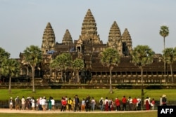 This picture taken on April 7, 2022 shows tourists visiting the Angkor Wat temple complex, a UNESCO World Heritage Site, in Siem Reap province. (Photo by TANG CHHIN Sothy / AFP)