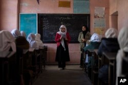 Seorang gadis Afghanistan membaca di ruang kelas di SMA Putri Tajrobawai, di Herat, Afghanistan, Kamis, 25 November 2021. (Foto: AP)