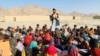 Matiullah Wesa, Afghan educational activist, reads a book to students at an open class in rural Afghanistan. (Photo courtesy of Matiullah Wesa)
