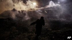 Para migran lari menyelamatkan diri dari gas air mata yang ditembakkan para petugas Dinas Perlindungan Perbatasan AS ke wilayah Meksiko di seberang pagar perbatasan setelah mereka memanjat pagar untuk sampai ke San Diego, California, dari Tijuana, Meksiko, 1 Januari 2019.