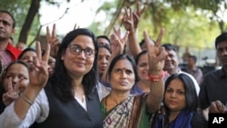 Asha Devi (tengah), ibu dari korban pemerkosaan beramai-ramai pada 2012, mengacungkan tanda kemenangan setelah pemerkosa anaknya dihukum gantung, di New Delhi, India, 20 Maret 2020. (Foto: AP)