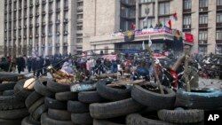 People are seen gathered in front of a barricade at the regional administration building in Donetsk, Ukraine, April 9, 2014. 