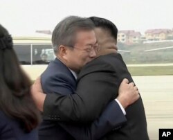 South Korean President Moon Jae-in, left, hugs North Korean leader Kim Jong Un upon arrival in Pyongyang, North Korea, Sept. 18, 2018.