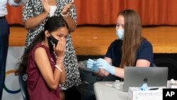FILE - A high school student reacts after getting a COVID-19 vaccine shot in New York City, July 27, 2021. 