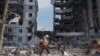 A clean up worker walks past buildings that were destroyed by Russian shelling, in Borodianka, in the Kyiv region, Ukraine, April 7, 2022. REUTERS/Marko Djurica 