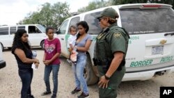 U.S. Border Patrol agent-in-charge Melissa Lucio, right, talks with women and children migrating from Honduras after they surrendered to U.S. Border Patrol agents after illegally crossing the border Monday, June 25, 2018, near McAllen, Texas. (AP Photo/Da