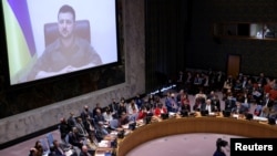 Ukrainian President Volodymyr Zelenskiy appears on a screen as he addresses the United Nations Security Council via video link during a meeting at the United Nations Headquarters in New York, April 5, 2022.