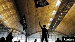 FILE - Protesters wave flags with Chinese calligraphy that reads "Liberate Hong Kong, the revolution of our times," at a demonstration in Hong Kong, China, Aug. 12, 2019. The documentary "Revolution of Our Times," about the protests, set a record in its first week of screening. 