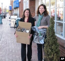 New Jersey shoe store owner Louise Van Osten and customer Jill Shobe with a carton of donated used shoes that are bound for Haiti.