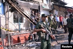 Tentara Sri Lanka berjaga di dekat sebuah rumah yang terbakar pasca bentrokan antara dua komunitas di Digana, distrik pusat Kandy, Sri Lanka, 6 Maret 2018.